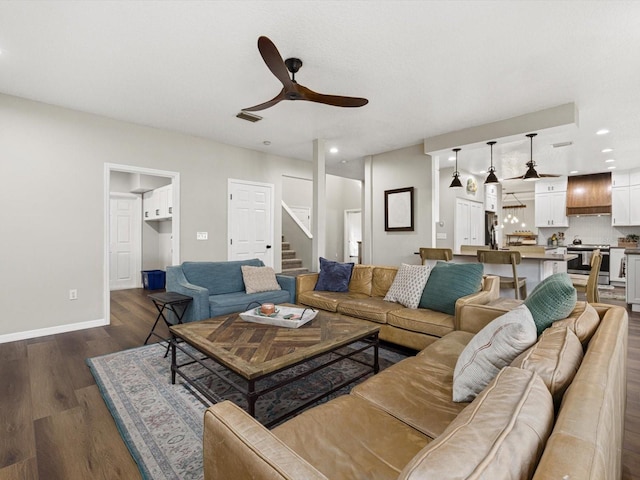 living room featuring ceiling fan and dark hardwood / wood-style flooring