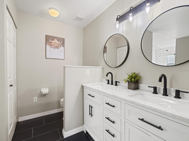 bathroom featuring vanity, a textured ceiling, toilet, and tile patterned flooring