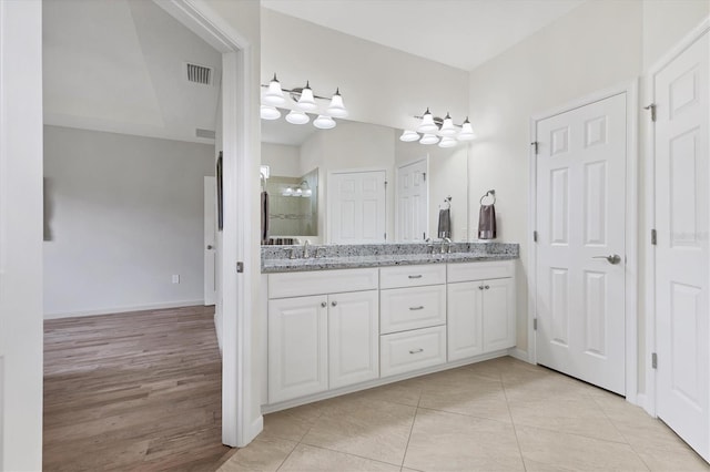 bathroom with tile patterned floors, vanity, and an enclosed shower