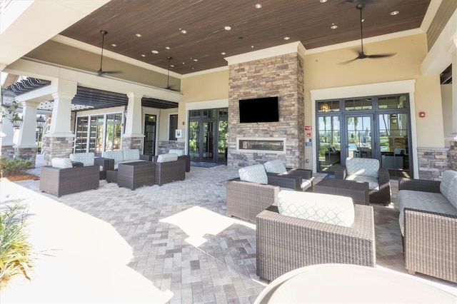 view of patio with an outdoor living space with a fireplace, ceiling fan, and french doors