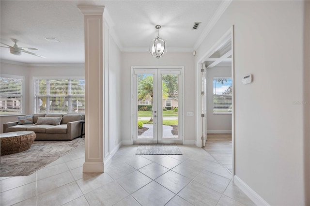 tiled entrance foyer with french doors, ceiling fan with notable chandelier, crown molding, and a textured ceiling