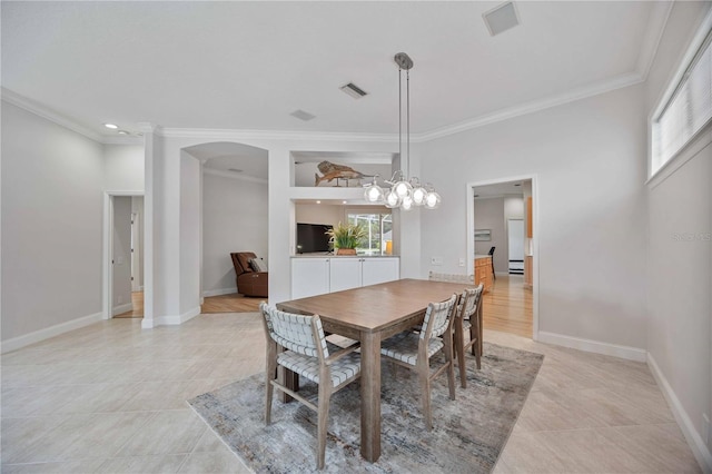 dining area with light tile patterned floors, crown molding, and a notable chandelier