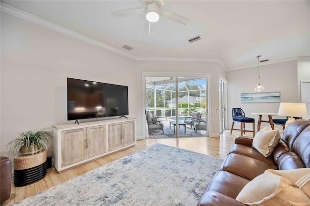 living room featuring ceiling fan, crown molding, and light hardwood / wood-style flooring