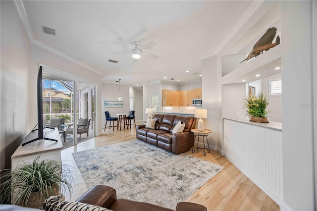 living room with ceiling fan, light hardwood / wood-style flooring, and crown molding