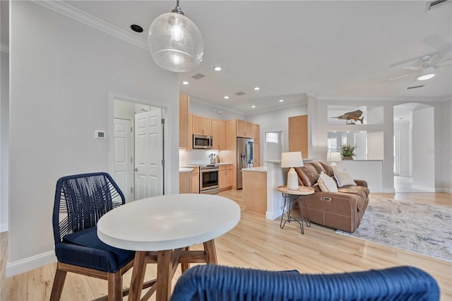 dining space featuring ceiling fan, ornamental molding, and light hardwood / wood-style flooring