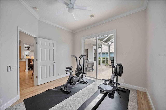 workout area featuring ceiling fan, ornamental molding, and hardwood / wood-style flooring