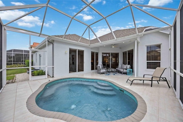 view of swimming pool featuring ceiling fan, glass enclosure, outdoor lounge area, and a patio