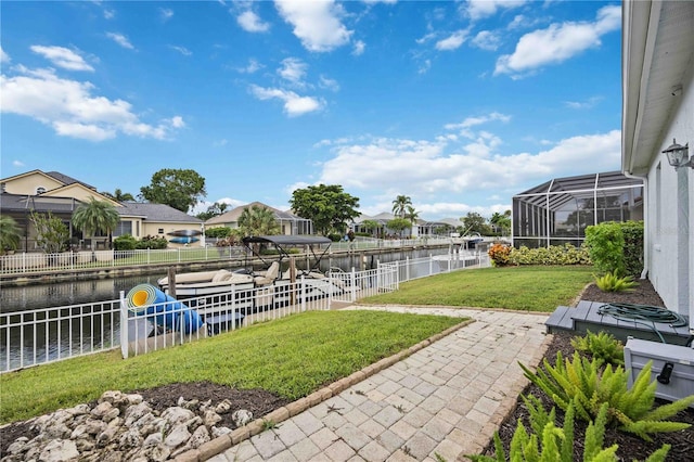 view of yard with a water view and a lanai