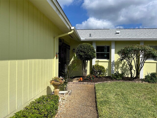 entrance to property featuring a lawn