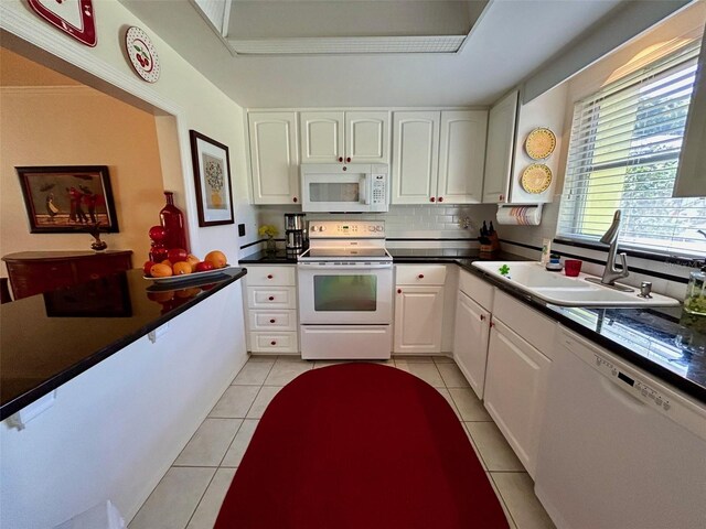 kitchen with sink, light tile patterned floors, white cabinets, white appliances, and backsplash