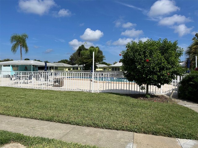 view of swimming pool featuring a patio and a yard