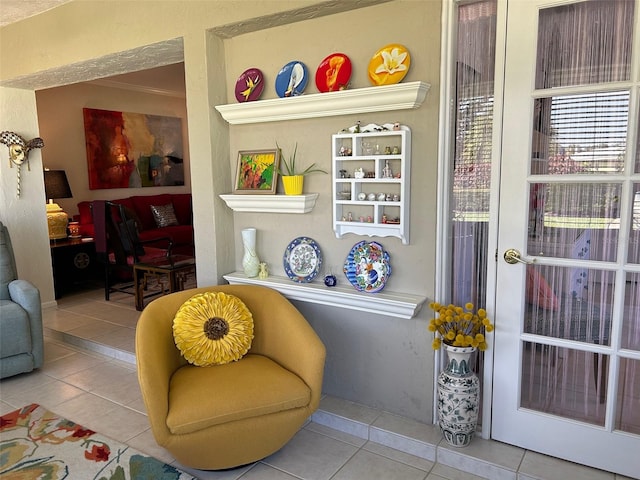 living area featuring ornamental molding and light tile patterned floors