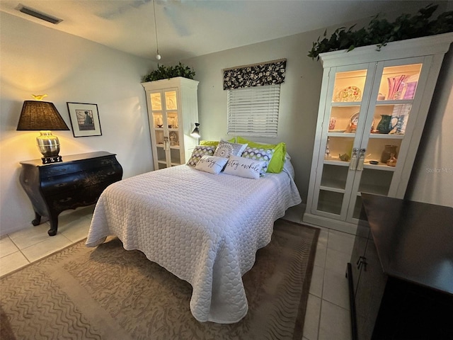 bedroom with ceiling fan and tile patterned flooring