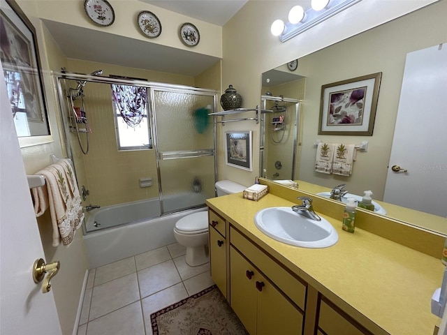 full bathroom featuring tile patterned flooring, bath / shower combo with glass door, vanity, and toilet