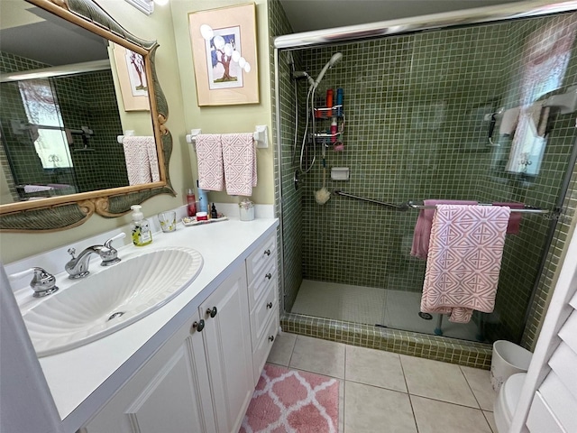 bathroom with tile patterned flooring, vanity, a shower with door, and toilet