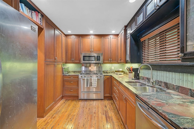 kitchen featuring sink, light hardwood / wood-style flooring, stone countertops, and appliances with stainless steel finishes