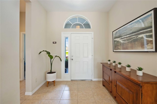 foyer featuring light tile patterned floors and a towering ceiling