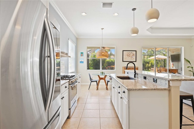 kitchen featuring white cabinetry, sink, hanging light fixtures, and stainless steel appliances