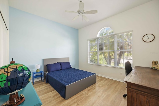 bedroom featuring ceiling fan, multiple windows, and light hardwood / wood-style floors