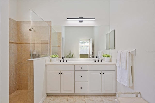 bathroom featuring vanity, tile patterned flooring, and tiled shower