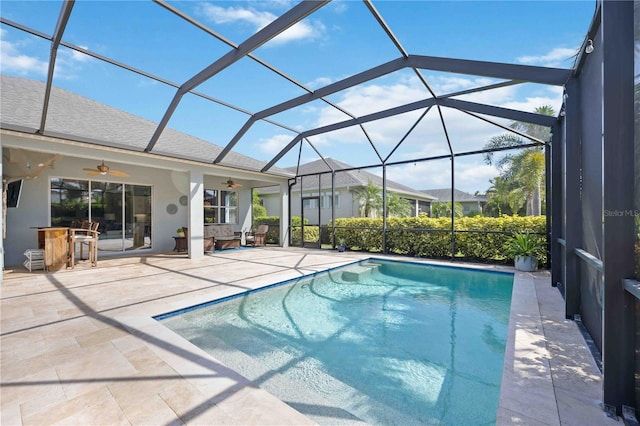 view of pool with ceiling fan, glass enclosure, and a patio