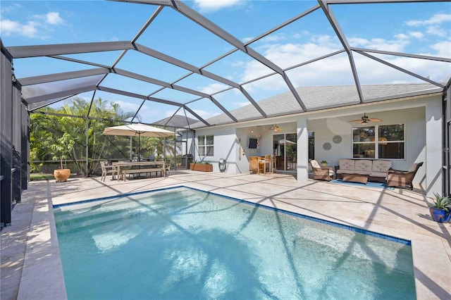 view of swimming pool with ceiling fan, an outdoor living space, a patio area, and glass enclosure