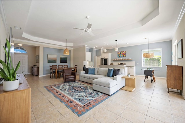 tiled living room featuring ceiling fan, crown molding, and a raised ceiling