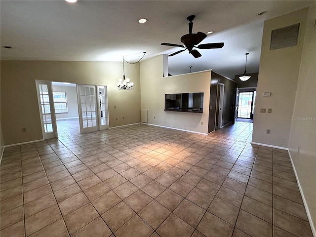 unfurnished living room with ceiling fan with notable chandelier, light tile patterned floors, and vaulted ceiling