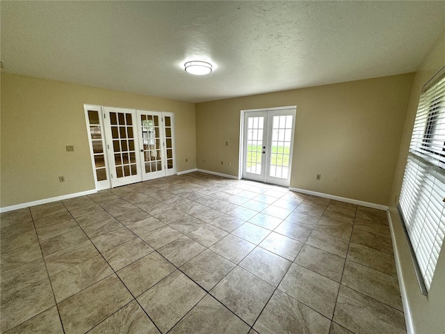 tiled spare room with french doors and a textured ceiling