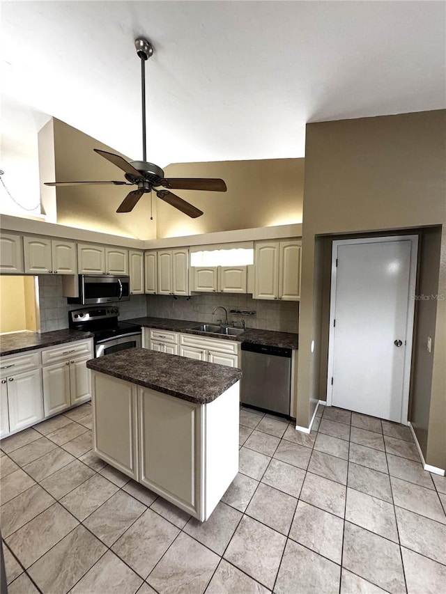 kitchen featuring stainless steel appliances, sink, tasteful backsplash, light tile patterned floors, and a kitchen island