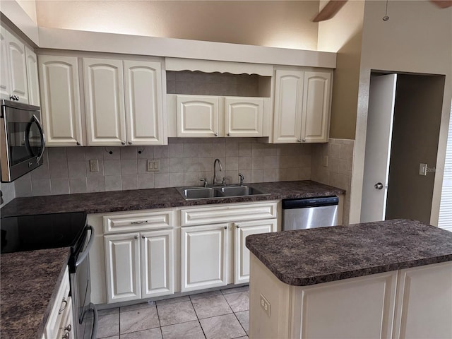 kitchen with white cabinets, stainless steel appliances, sink, and backsplash