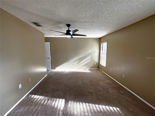 empty room featuring a textured ceiling, carpet floors, and ceiling fan