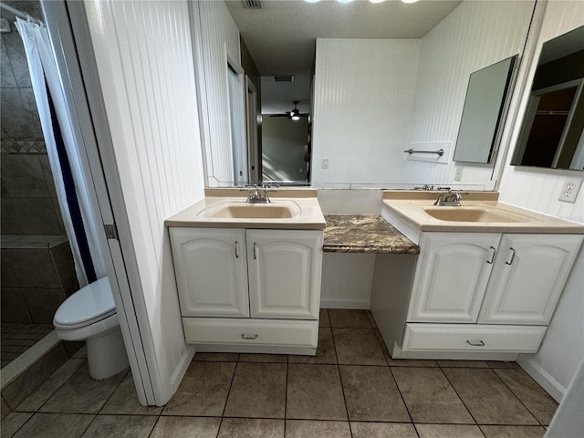 bathroom with tile patterned floors, toilet, a textured ceiling, a shower with curtain, and vanity