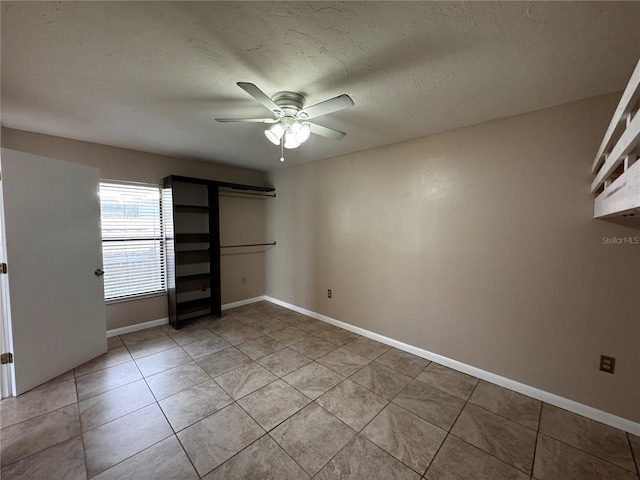 tiled spare room featuring ceiling fan and a textured ceiling