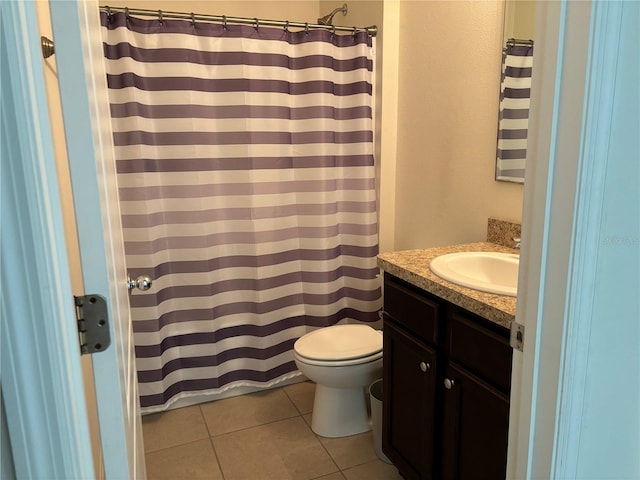 bathroom featuring walk in shower, vanity, toilet, and tile patterned floors