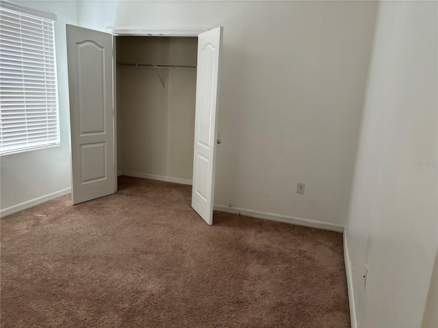 unfurnished bedroom with carpet flooring and a closet