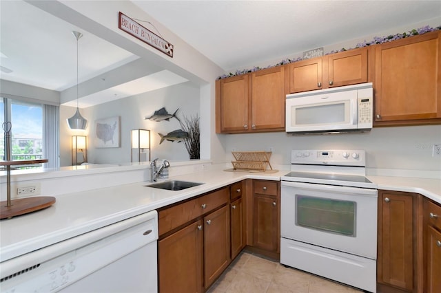 553 Bahia Beach Blvd, Ruskin, FL 33570 - kitchen with hanging light fixtures, light tile patterned floors, kitchen peninsula, sink, and white appliances