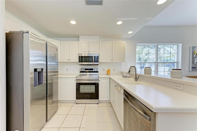 kitchen with sink, white cabinetry, stainless steel appliances, and light tile patterned floors