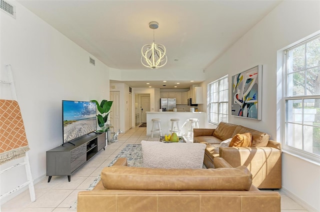 living room with light tile patterned floors and a chandelier