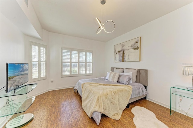 bedroom featuring hardwood / wood-style floors and an inviting chandelier