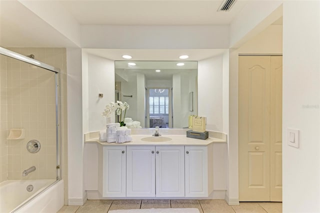 bathroom with vanity, tile patterned flooring, and bath / shower combo with glass door