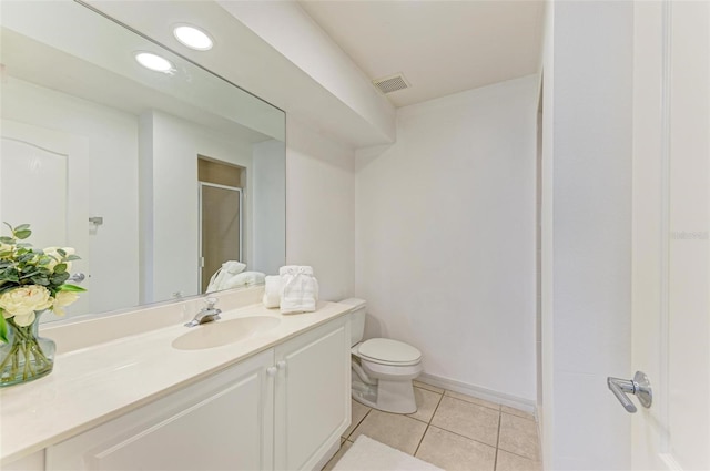 bathroom with vanity, toilet, tile patterned floors, and a shower with door