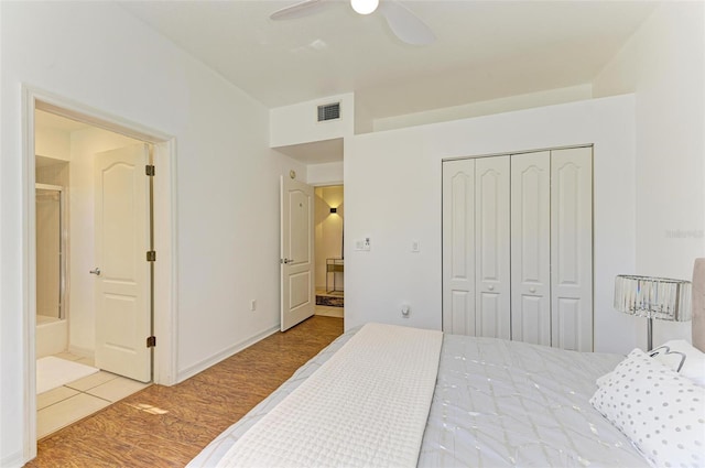 bedroom with a closet, light hardwood / wood-style floors, ensuite bathroom, and ceiling fan