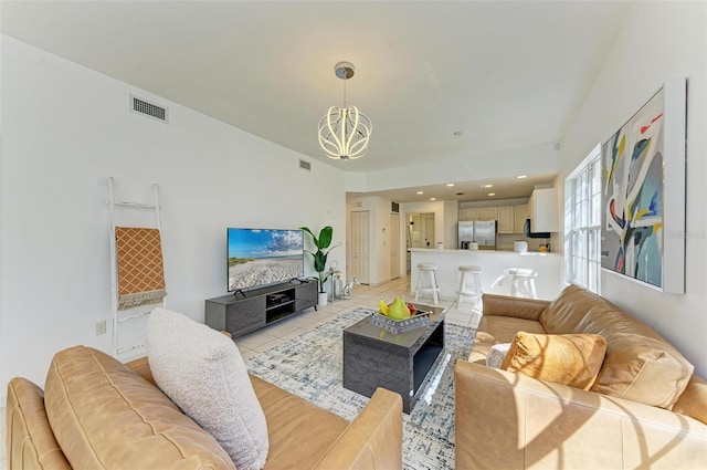 living room featuring a notable chandelier and light tile patterned floors