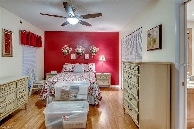 bedroom featuring ceiling fan, light wood-type flooring, and a closet