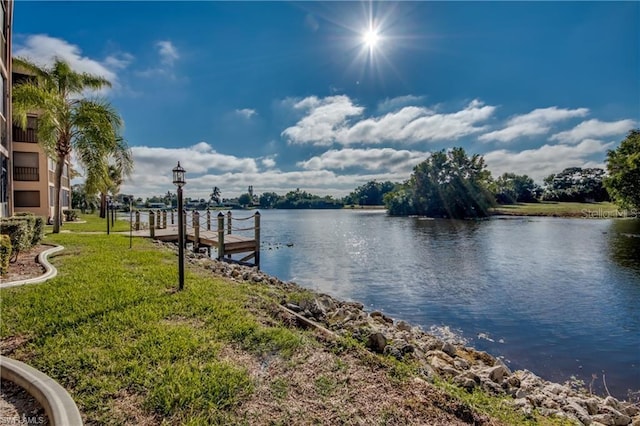 dock area featuring a lawn and a water view