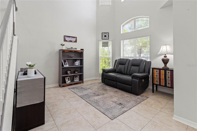 living area with light tile patterned flooring and a towering ceiling