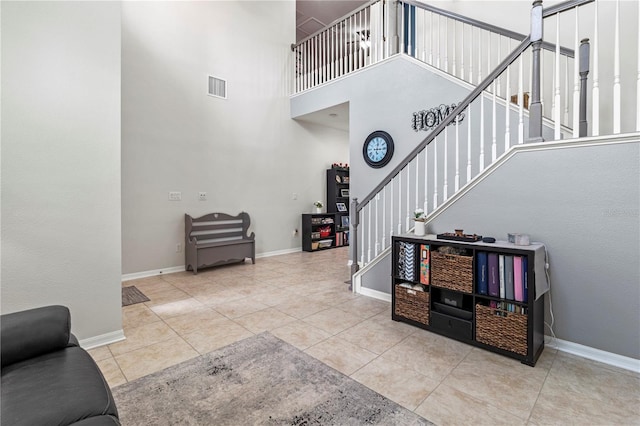 stairway featuring a high ceiling and tile patterned flooring