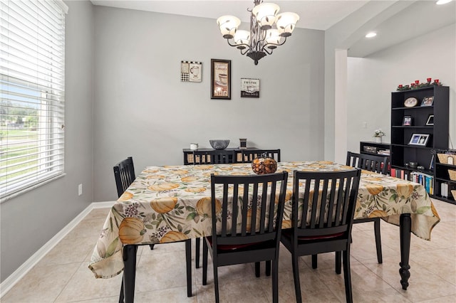 tiled dining room featuring a chandelier