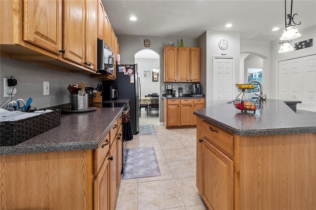 kitchen with decorative light fixtures, light tile patterned flooring, stainless steel appliances, and a kitchen island